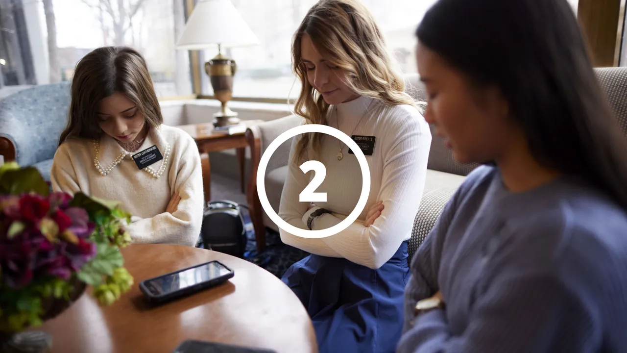 Missionaries praying with a woman before studying together
