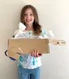 Girl holding cardboard wagon