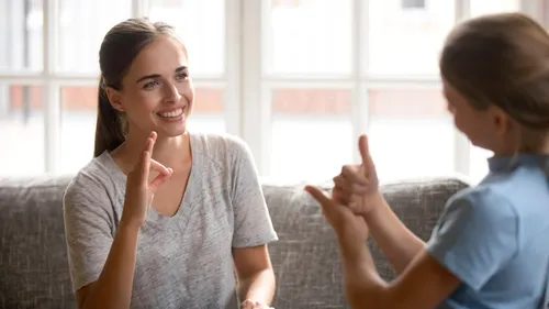 a mother talks to her daughter using sign language