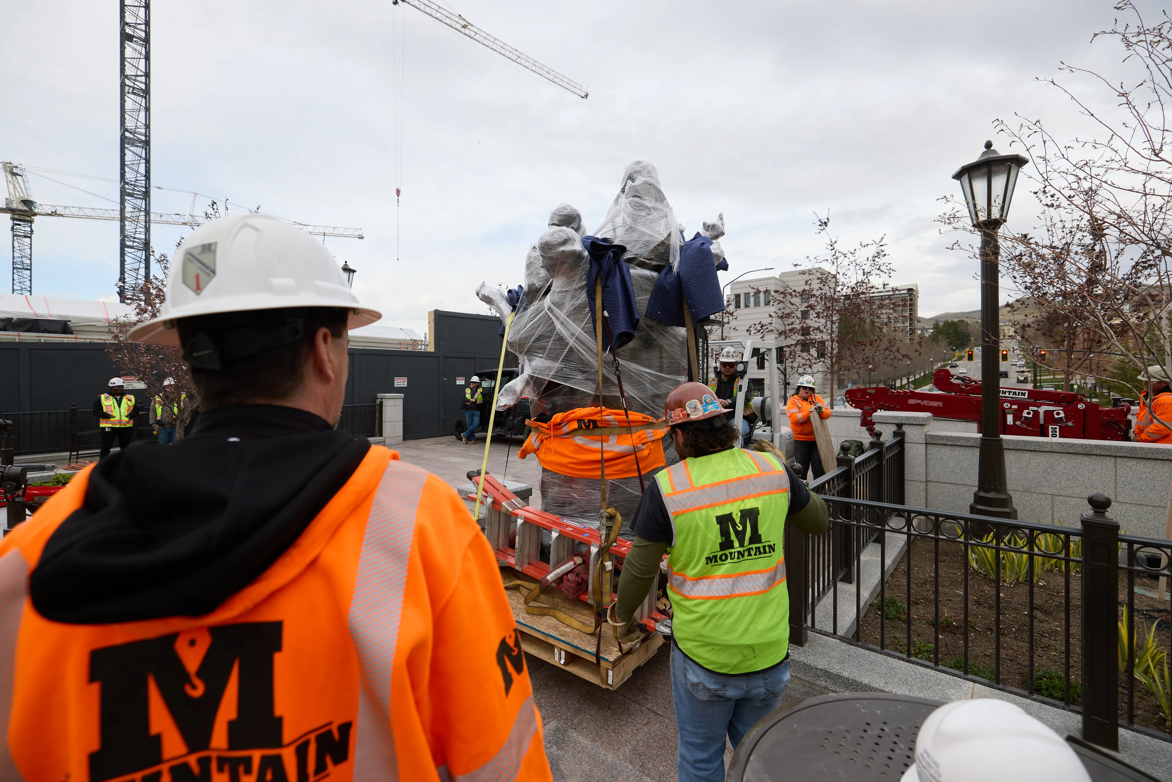 Crews install a new sculpture titled “Five Wise Virgins” on the east side of Temple Square near the Relief Society building in Salt Lake City, Utah, on Monday, March 31, 2025.