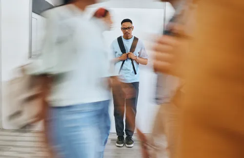 a man looking sad as people walk all around him