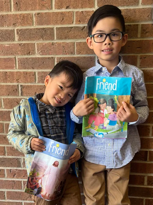 Photo of two boys holding copies of the Friend magazine