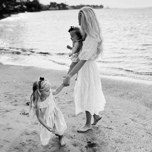 和年幼女儿一起在沙滩上的妇女