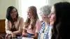A young woman is sitting and talking to some older sisters in Relief Society