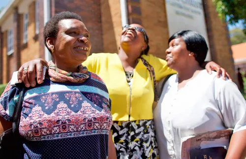 three women standing together and laughing