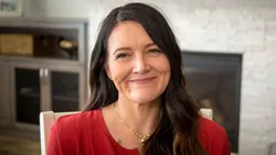 A woman smiles into the camera