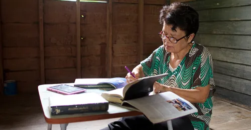 woman sitting at table and writing