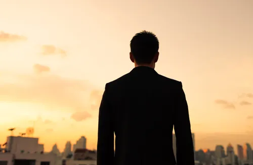 silhouette of a man staring at a city