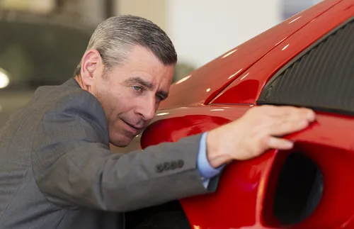 man looking at fancy car