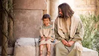 Jesus Christ sits with a young child teaching His disciples to become as little children