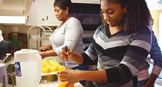 mother and daughter preparing fruit