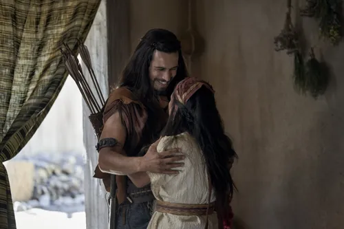Enos greets his wife in their home.