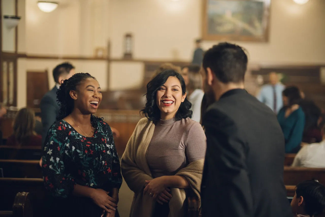 Church members greet one another at the end of a Sunday service