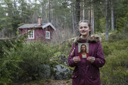 young woman in Norway holding a picture of Christ