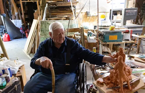 man in a wheelchair looking at a piece of sculpture
