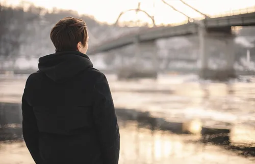 Young man looking over river