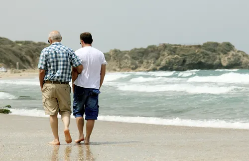 father and son walking on beach