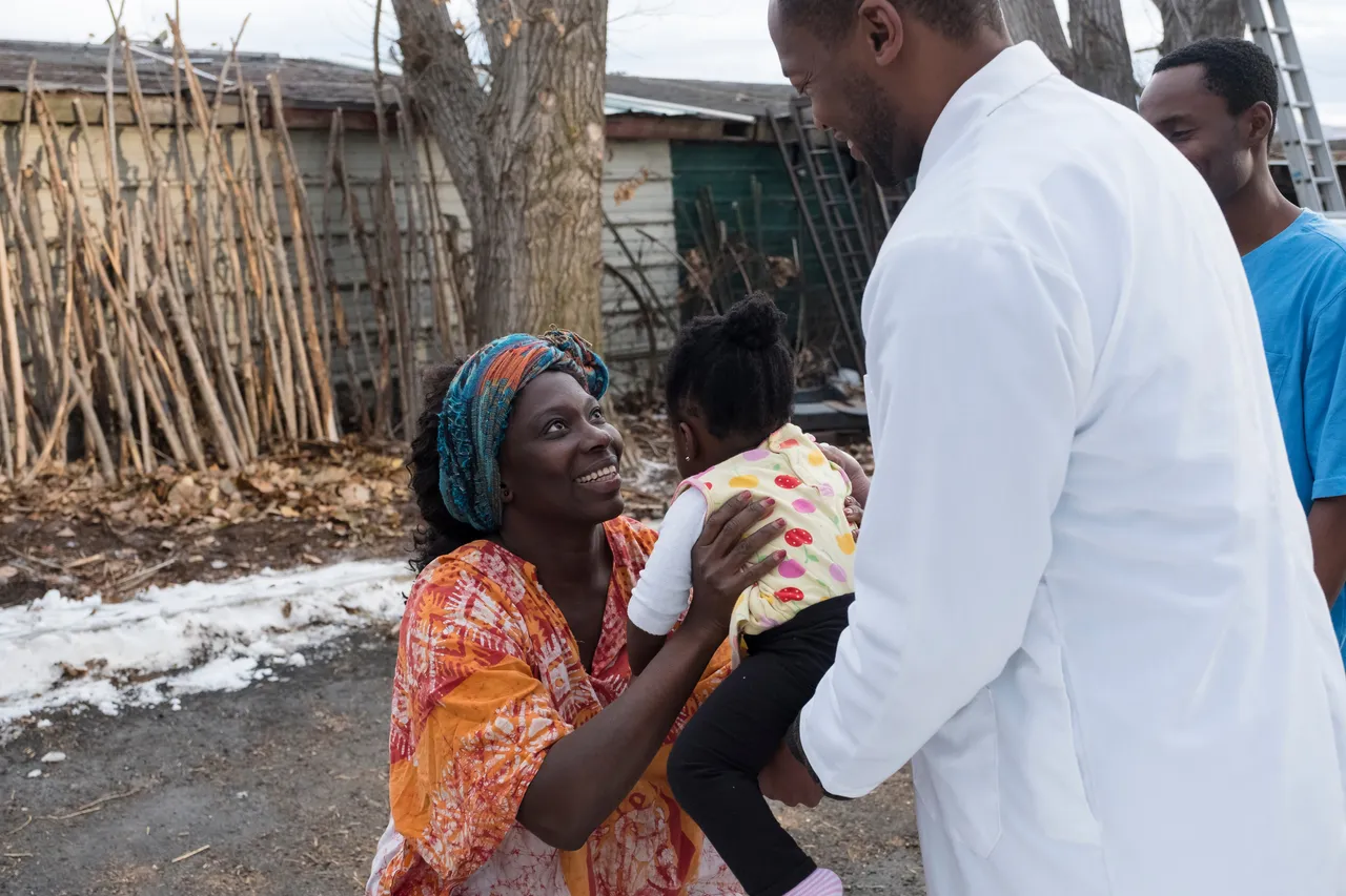 A woman holds her child as she smiles
