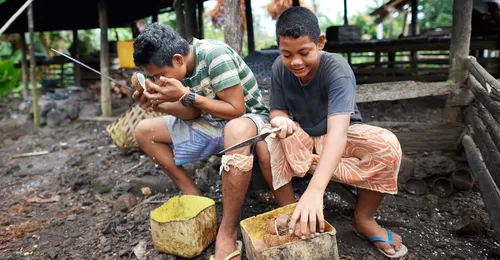 boys shelling coconuts