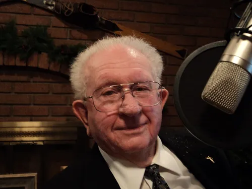 Harold Wood beside a radio microphone.