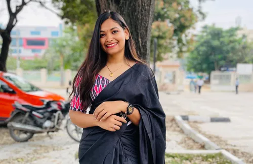 a young woman standing and smiling