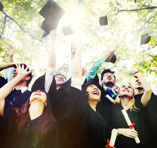 graduates throwing cap into the air