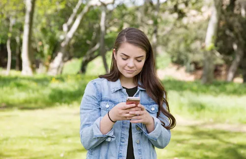 a woman looking at her phone and smiling