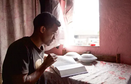 a young adult setting the habit of reading his scriptures