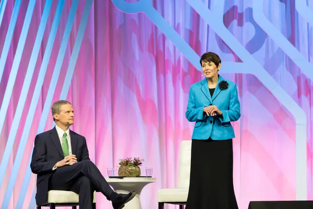Elder David A. Bednar and Sister Susan Bednar stand in front of an audience and talk with them in the Salt Palace during RootsTech 2019 in Salt Lake City, Utah.