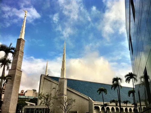 The side of the Taipei Taiwan Temple, with a view of the spires and the arches on the side of the building and a partial view of the grounds, including palm trees.
