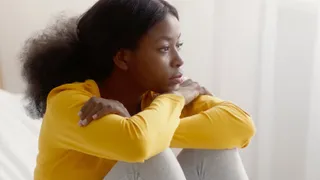 Young woman sitting looking off into the distance