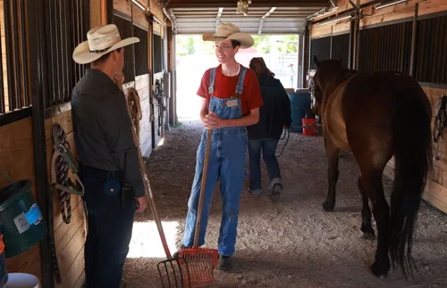 兩個人在牧場的馬廄裡說話