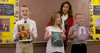 three children holding up pictures of Jesus at front of church room