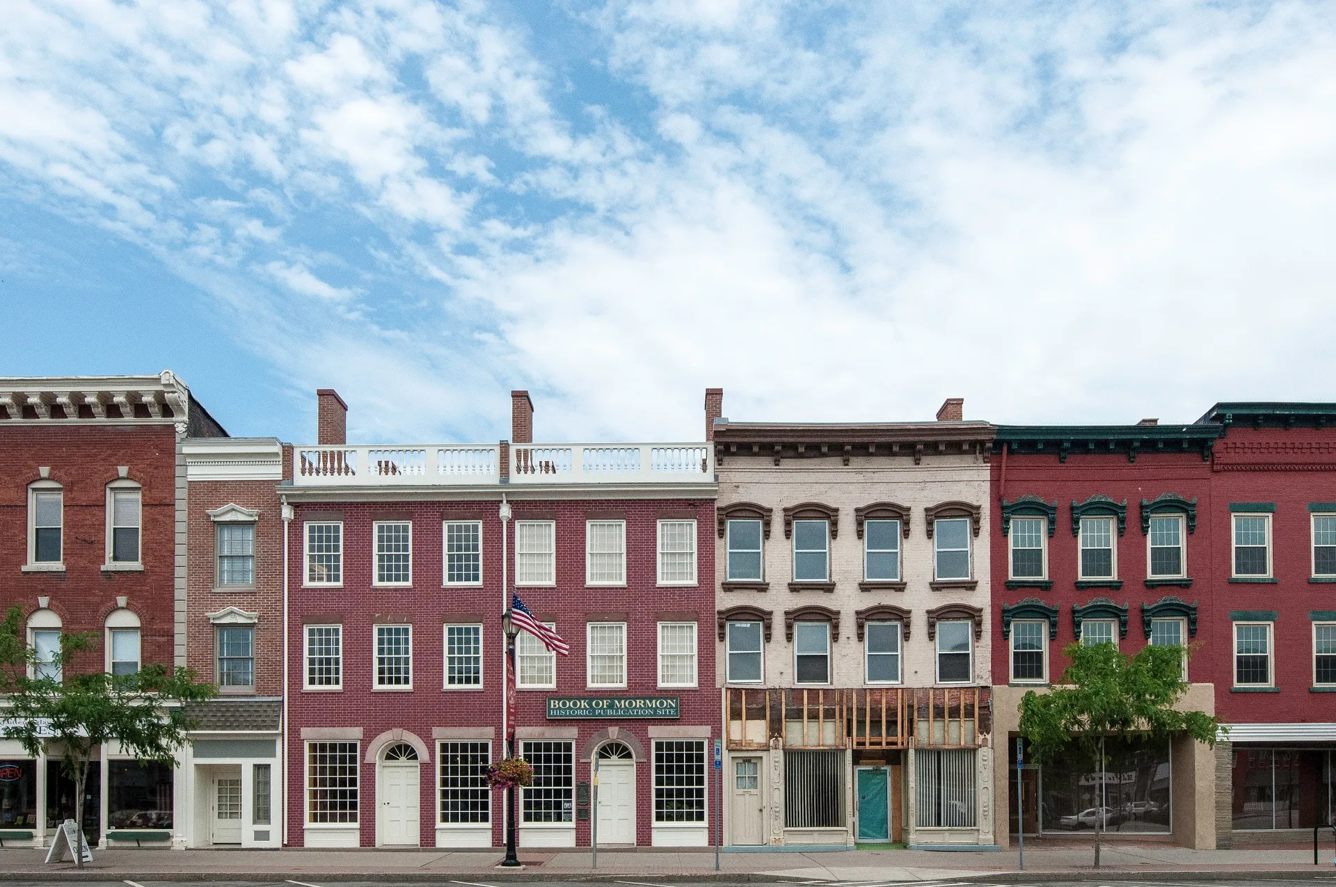 The exterior of the Grandin Press Building in a row of other buildings in Palmyra, New York.  