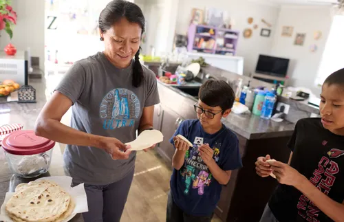 woman in a kitchen with her sons