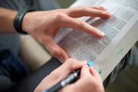 A man marks passages about prayer found in the Book of Mormon