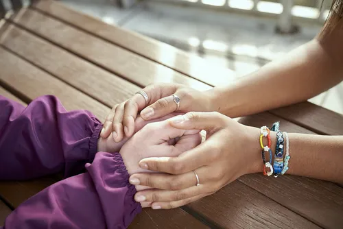 two people holding hands across a table