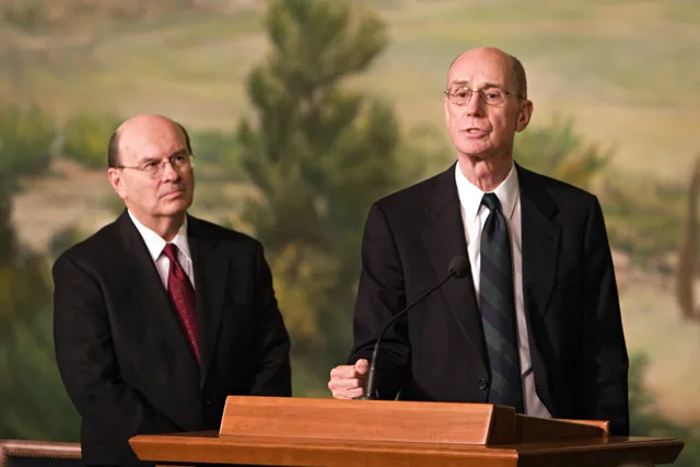 Elder Quentin L. Cook looks on as President Henry B. Eyring speaks to members of the press about Elder Cook's recent call to the apostleship.