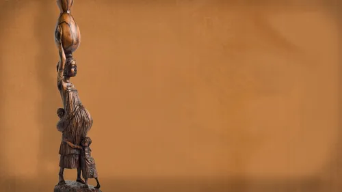 Wooden sculpture of an African woman and two children.