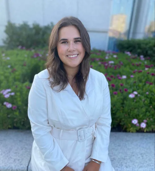 woman sitting in front of flowers and smiling