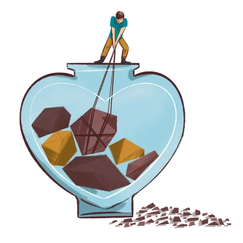 young man pulling rocks out of an oversized, heart-shaped jar