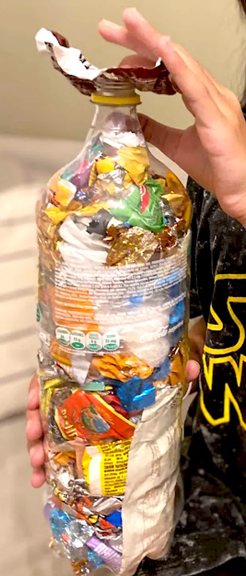 Plastic bottle filled with plastic trash