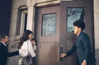 A man holds a church door open for a young family