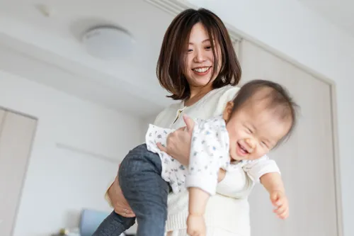 a mother lifts up her young daughter and swings her around