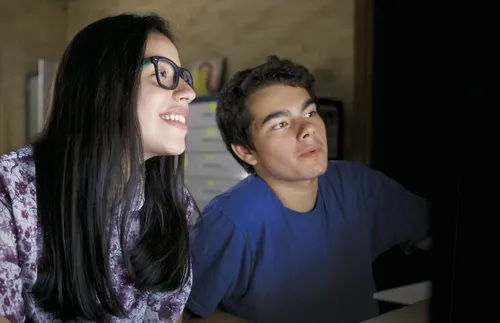 young woman and young man looking at computer screen