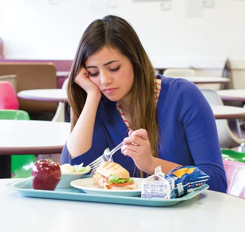 woman staring at food on plate