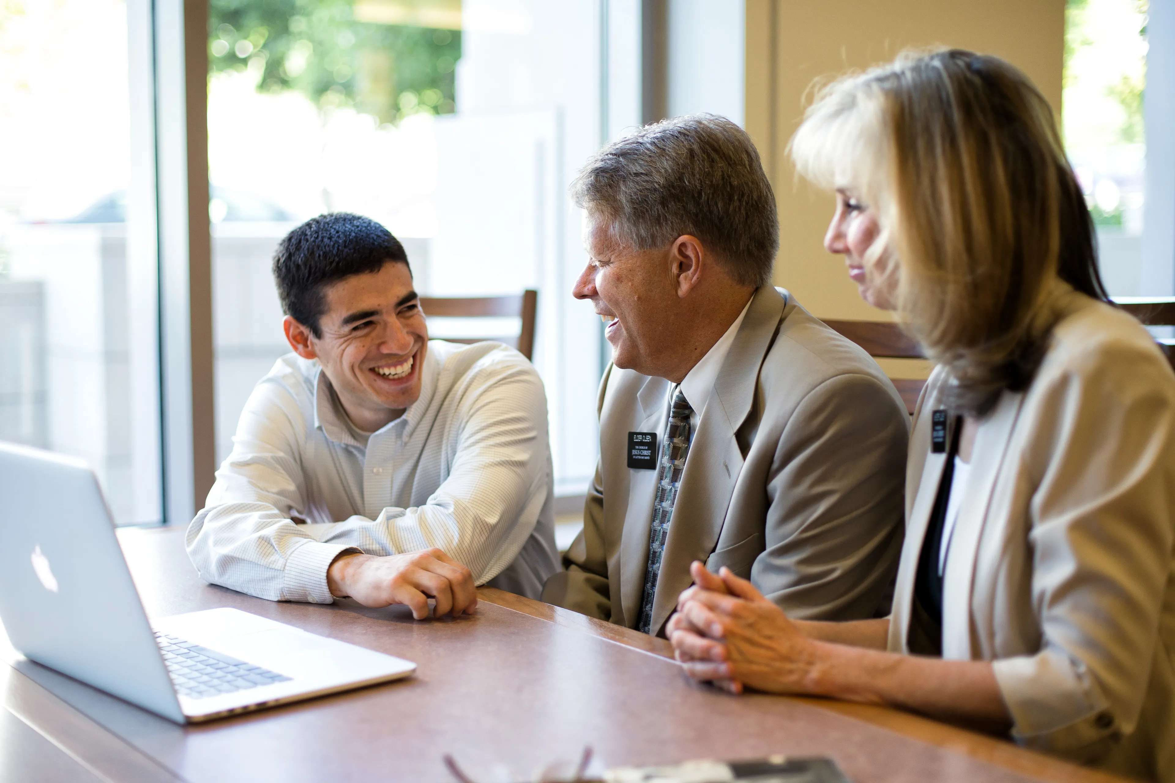 A senior missionary couple teaching a man about family history. Â 