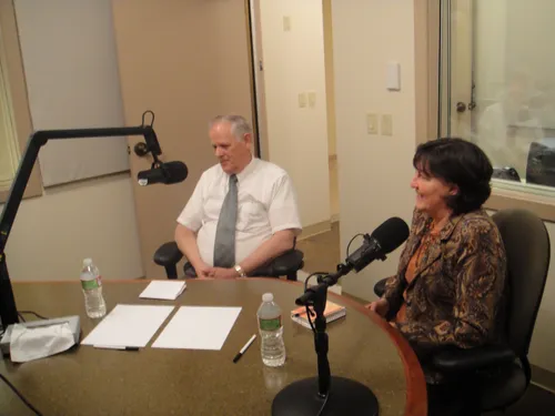 Screen capture from the program "Faith in Action."  Two people sitting at a table with microphones. Episode 18: Capaner Balarus.