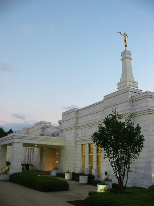 A side view of the entrance to the Birmingham Alabama Temple lit up in the evening.