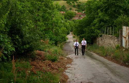 two young male missionaries walking along a street